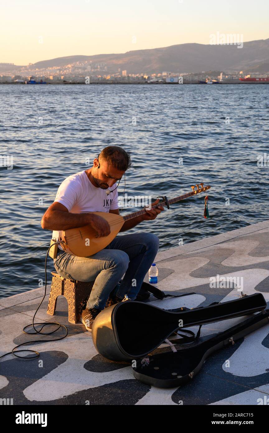 Uomo che suona un saz, un tradizionale strumento musicale turco, sul lungomare di Kordon a Izmir, Turchia Foto Stock