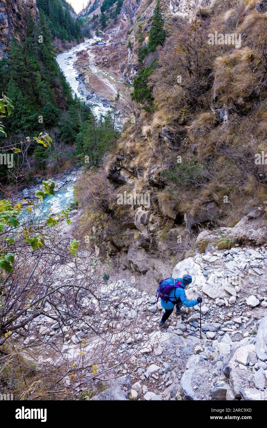 Trekker su un sentiero roccioso attraverso una gola del fiume a Dampo, Nepal Himalaya Foto Stock
