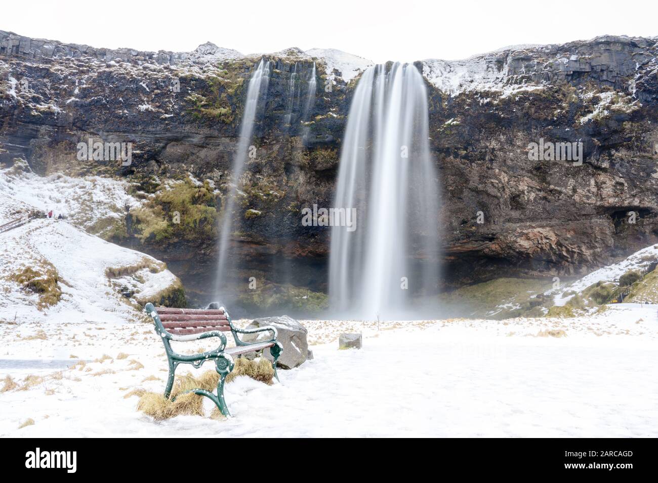 Cascata Seljalandsfoss nella stagione invernale con panca Foto Stock