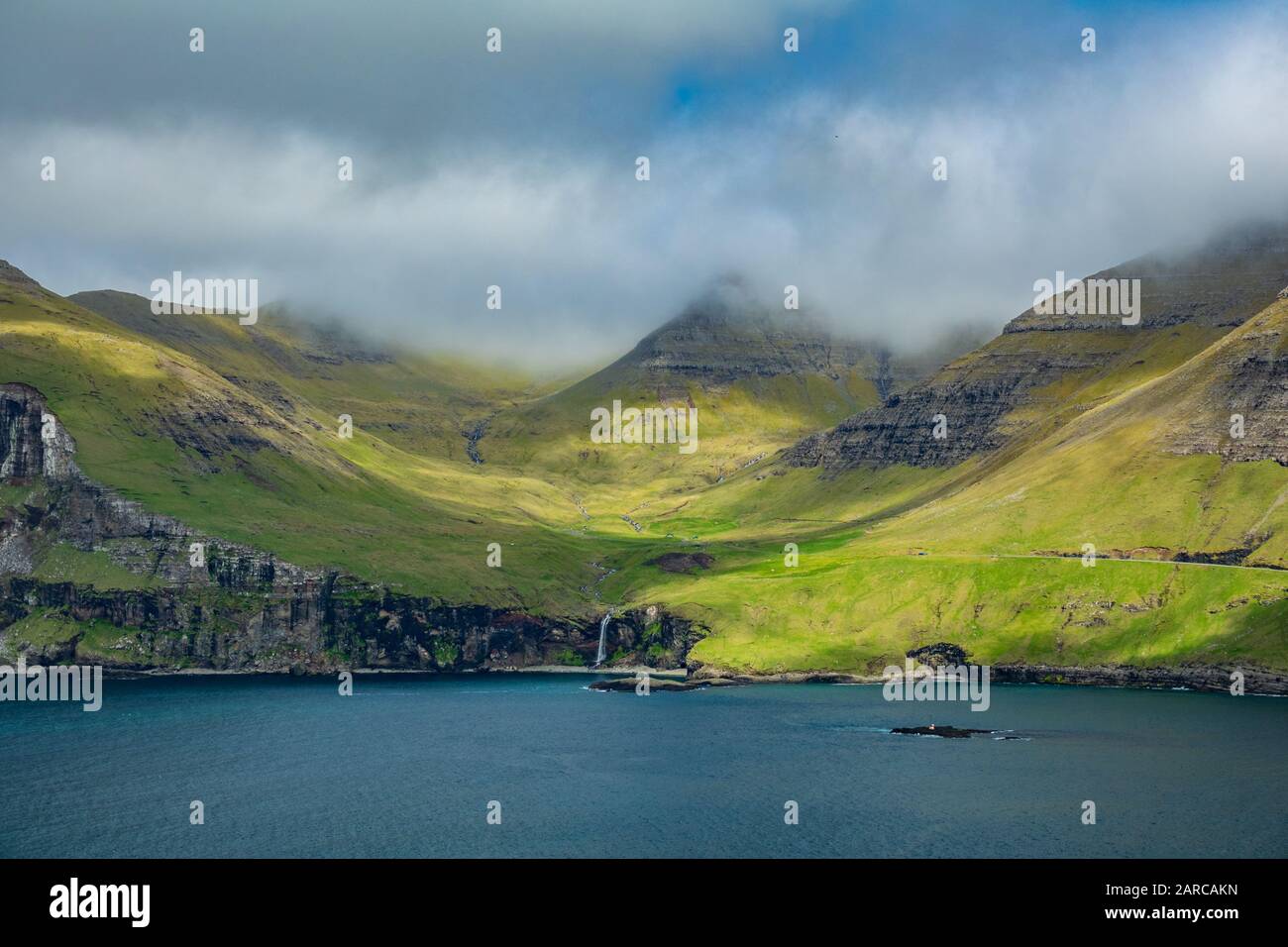 Tipica costa delle isole Faroe con cascata Foto Stock