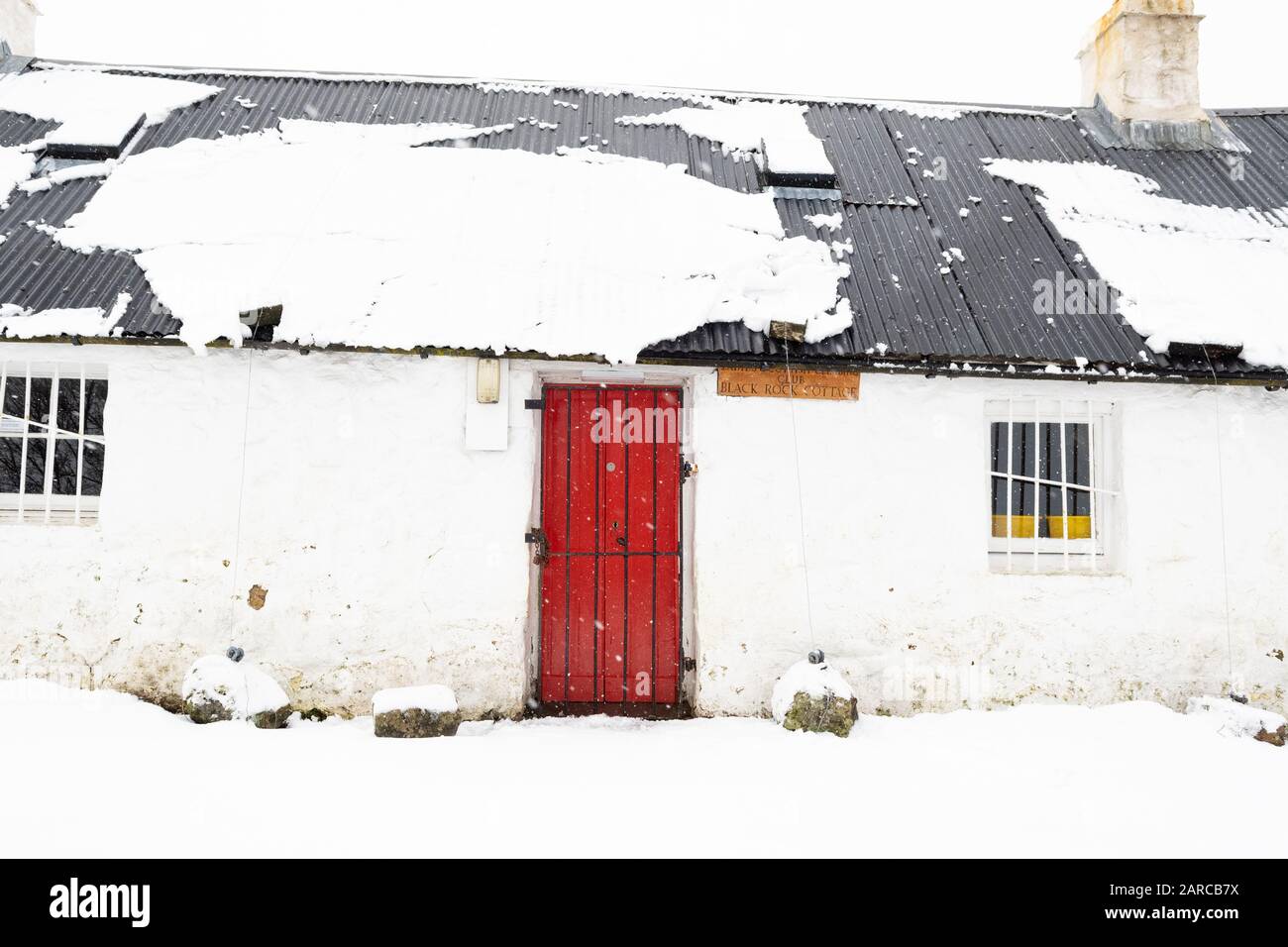 Glen Coe, Scozia, Regno Unito. 27th Gen 2020. Tempo nel Regno Unito - una coperta fresca di neve è stata veloce per scivolare fuori dal tetto dell'iconico Black Rock Cottage a Glen Coe, Scotland Credit: Kay Roxby/Alamy Live News Foto Stock