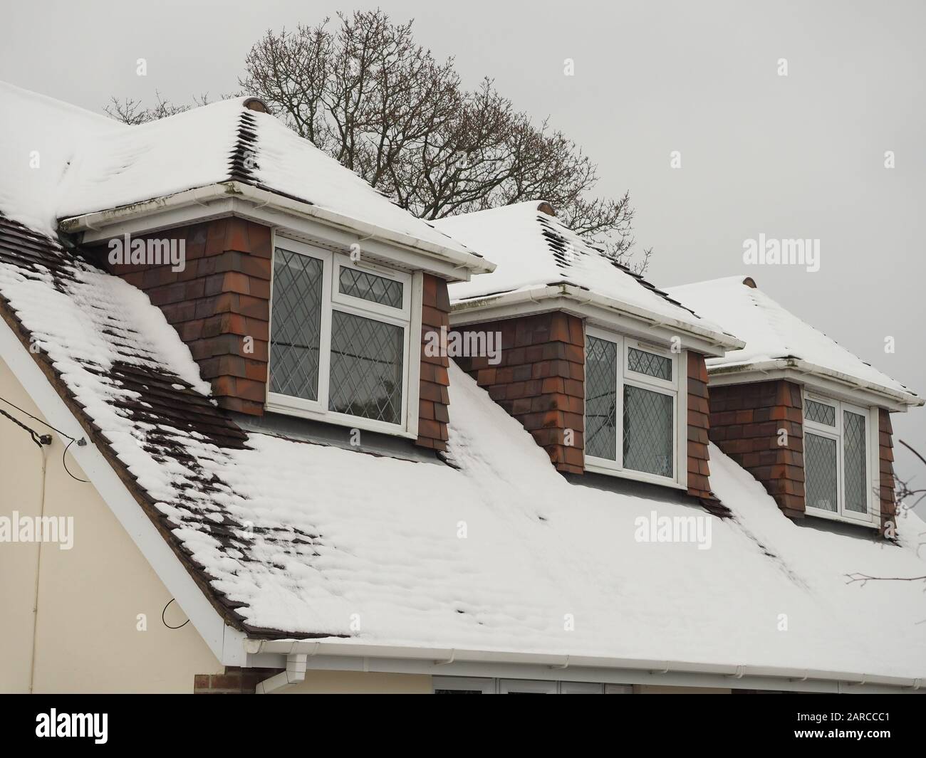 un tetto dormer con tre stanze in esso sotto una copertura di neve Foto Stock