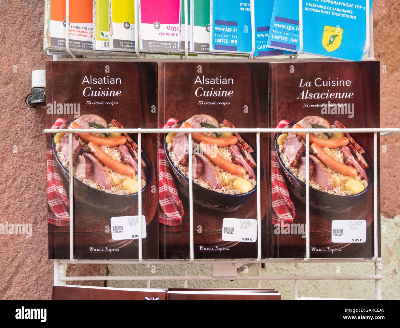 Libri di ricette per la tradizionale sauerkraut alsazia e carne in vendita al di fuori di un negozio a Riquewihr Alsazia Francia Foto Stock