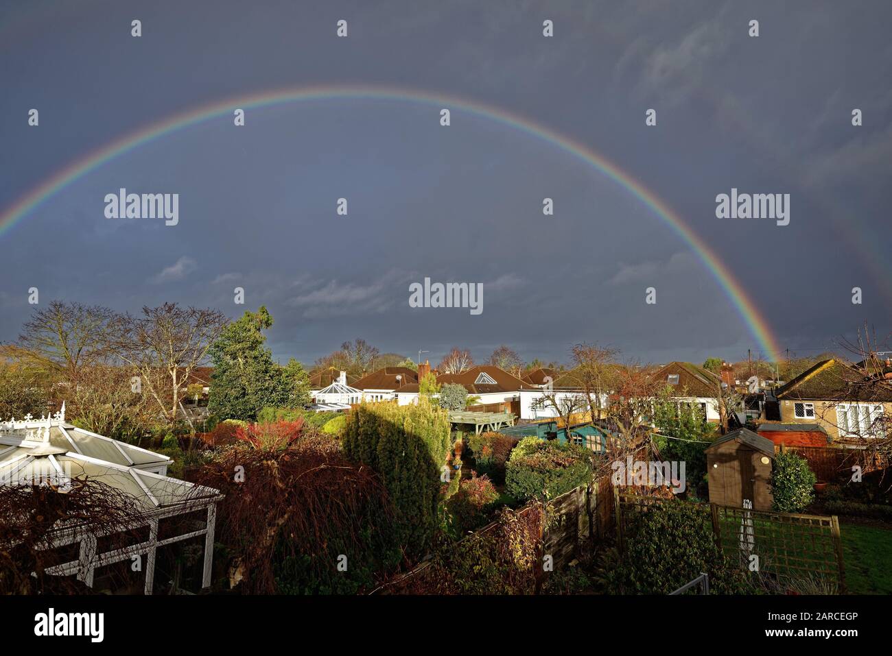 Un arcobaleno si formò sui tetti delle case suburbane in Shepperton Surrey Inghilterra UK Foto Stock
