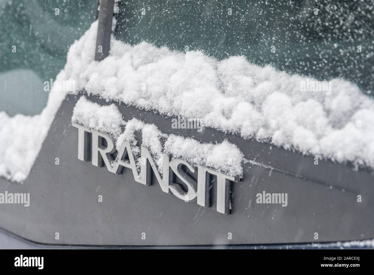 Bordo del finestrino coperto da neve del veicolo Ford Transit di un costruttore. Neve che provoca perturbazioni sulle strade e sul lavoro. Metafora del tempo invernale, maltempo. Foto Stock