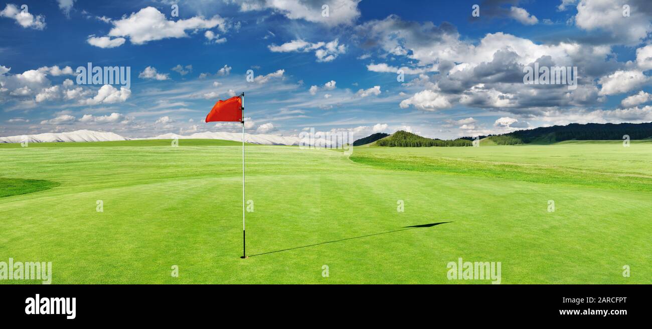 Panorama del campo da golf con bandiera rossa in un buco Foto Stock