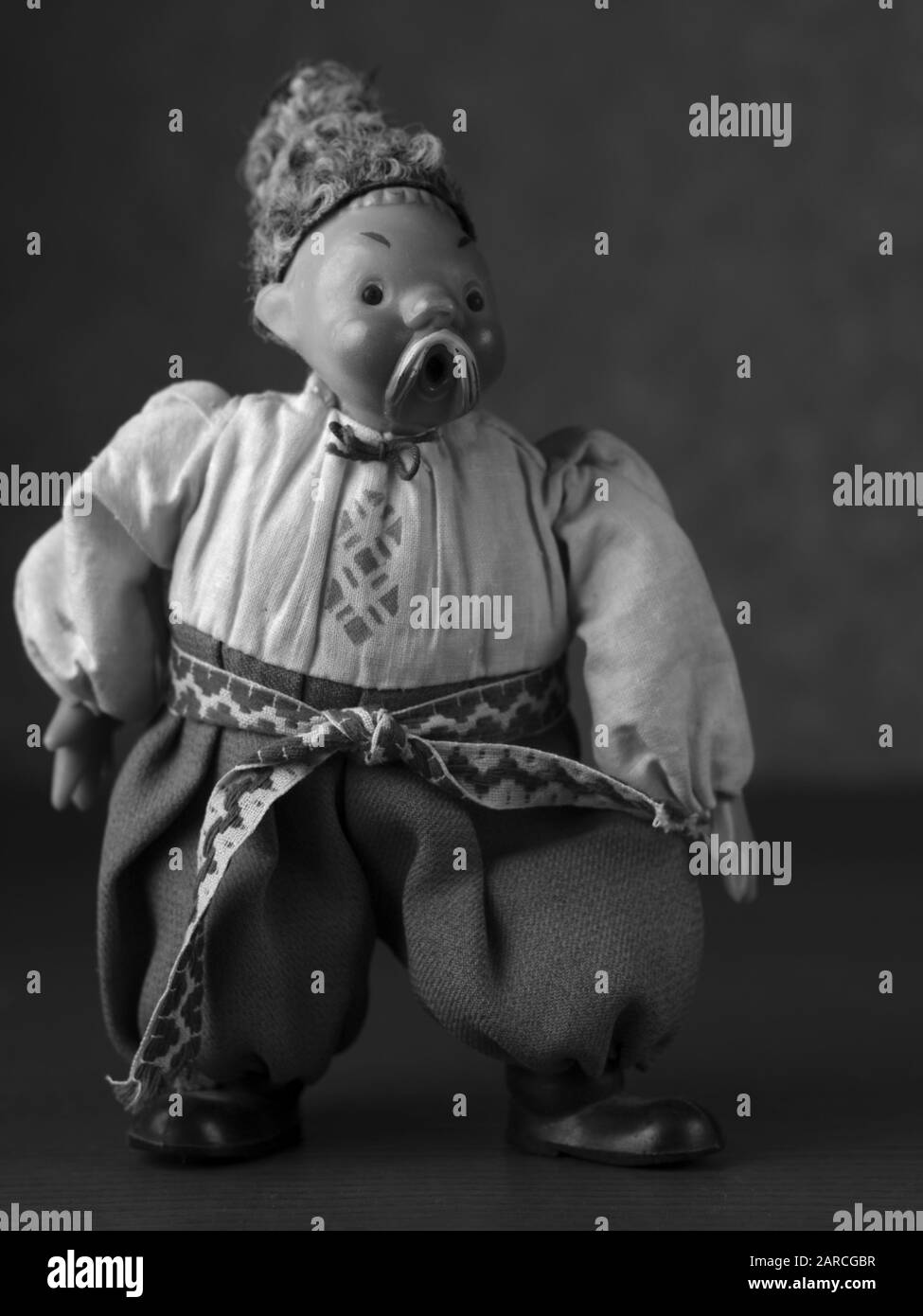 Immagine verticale in scala di grigi di una statuina maschile slavo che indossa la tradizione abbigliamento Foto Stock