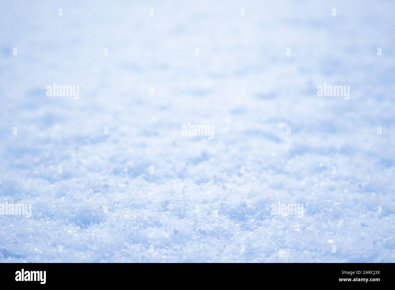 Bianco brillante luce blu neve macro inverno texture con sfondo sfocato. Naturale freddo soleggiato primo piano Foto Stock