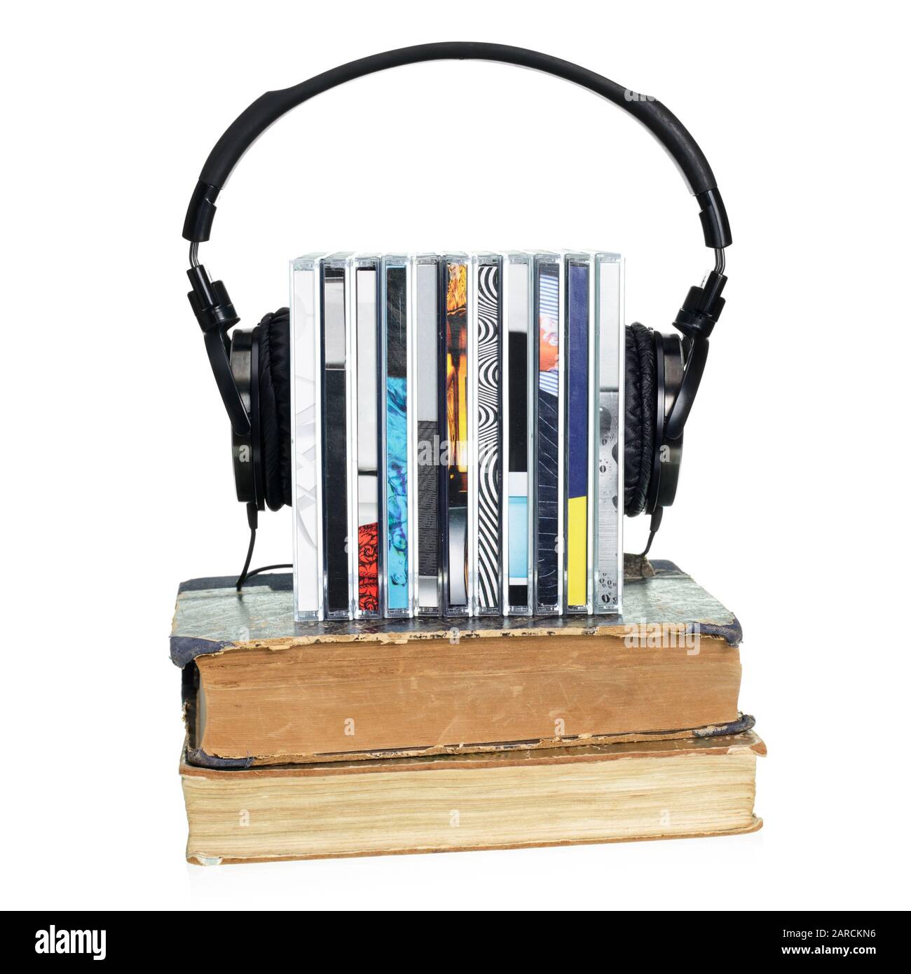 Pila di cd con hi-fi cuffie e vecchi libri su sfondo bianco Foto Stock