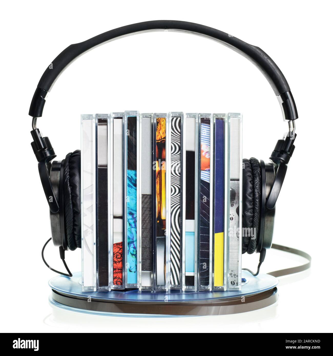 Pila di cd con hi-fi cuffie su vintage bobina di nastro audio su sfondo bianco Foto Stock