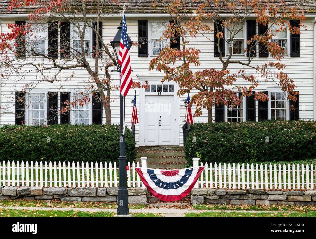 Affascinante casa coloniale con bandiera patriottica americana. Foto Stock