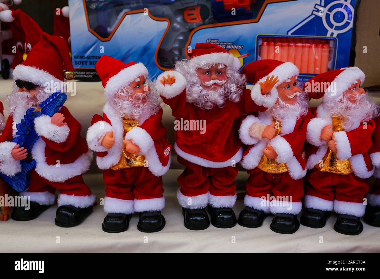 Figurine di Babbo Natale con campane su uno stand di strada Foto Stock