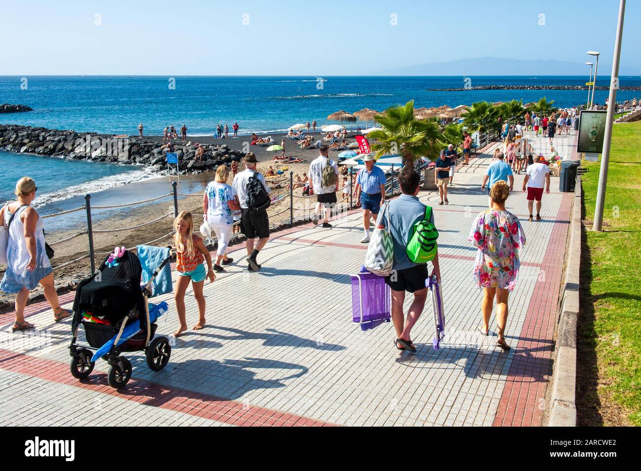Canary ISLAND TENERIFE, SPAGNA - 27 dicembre 2019: Turisti che camminano sul lungomare lungo Playa El Duque. E’ una delle spiagge più popolari di Tenerife. Foto Stock