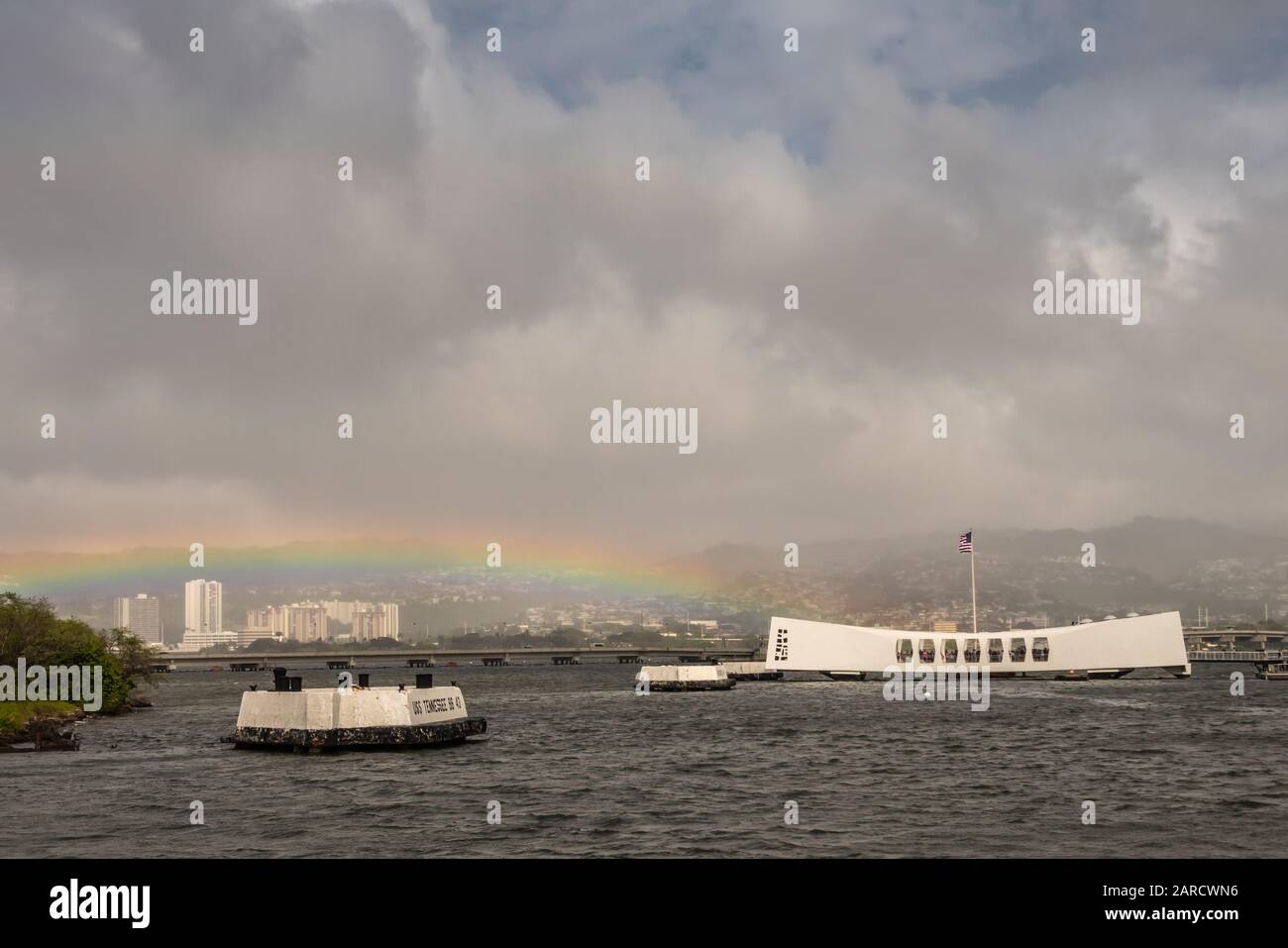 Oahu, Hawaii, Stati Uniti. - 10 Gennaio 2020: Pearl Harbor. Rainbow tocca White USS Arizona Memorial e il ponte Ford Island sul retro. Colline con costruzione bianca Foto Stock