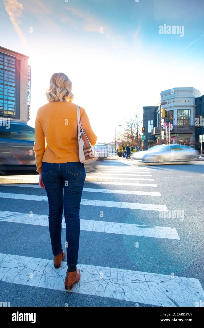USA Maryland Bethesda Pedestrian sicurezza donna che attraversa in un incrocio con il traffico auto Foto Stock