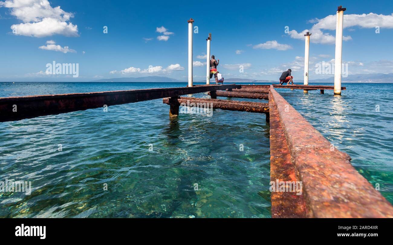 spettacolare immagine del vecchio molo arrugginito sulla costa caraibica con acqua blu utilizzata per la pesca. Foto Stock