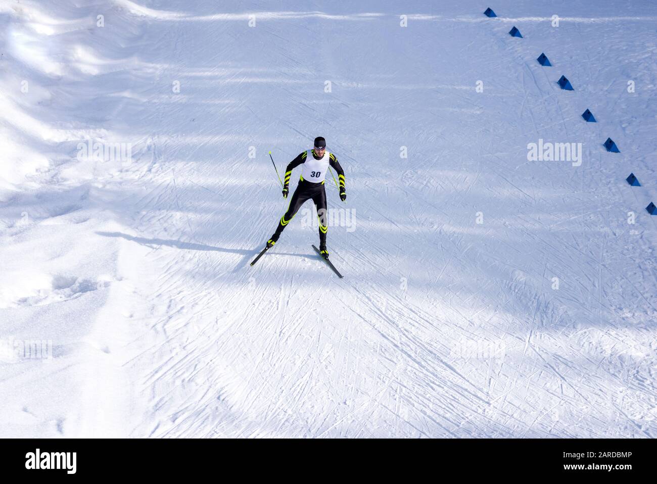 Una gara maschile di sci di fondo sul sentiero. Uomo in moderni vestiti da sci con il numero sul petto Foto Stock