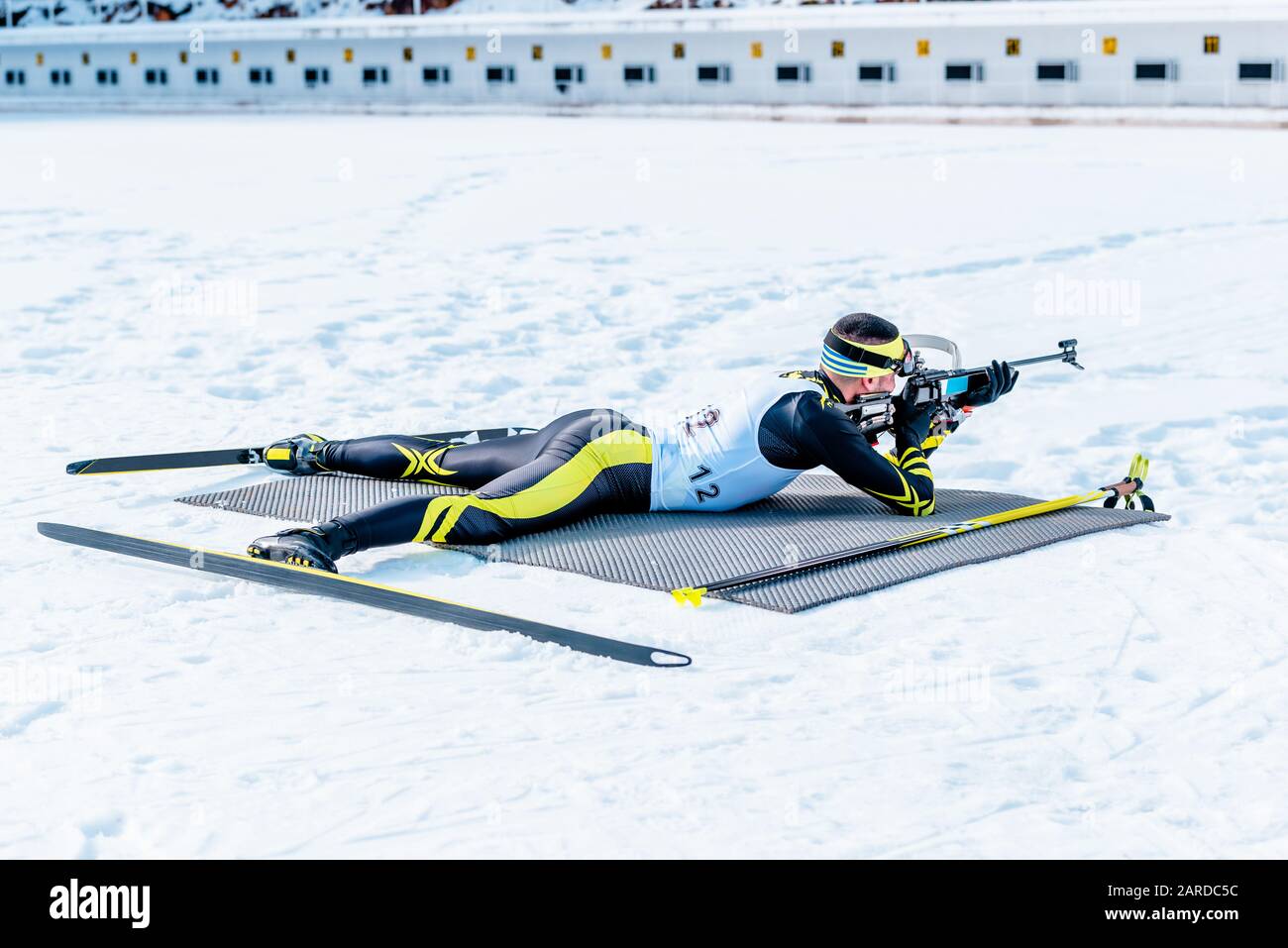 Biathlon bugie e tiro obiettivo con fucile. Ampio angolo. Gamma di scatto in background Foto Stock