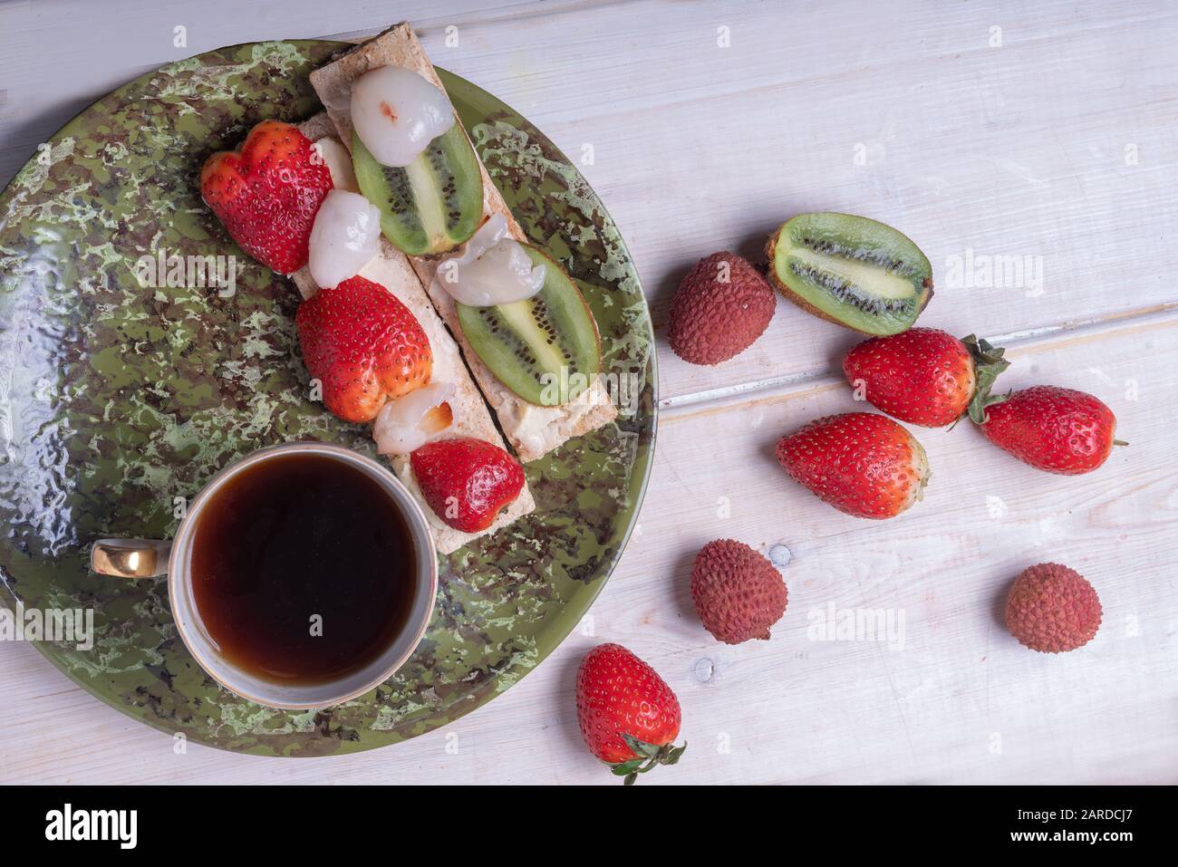 Panini con frutta - con kiwi, fragole, lychee e tè tazza Foto Stock