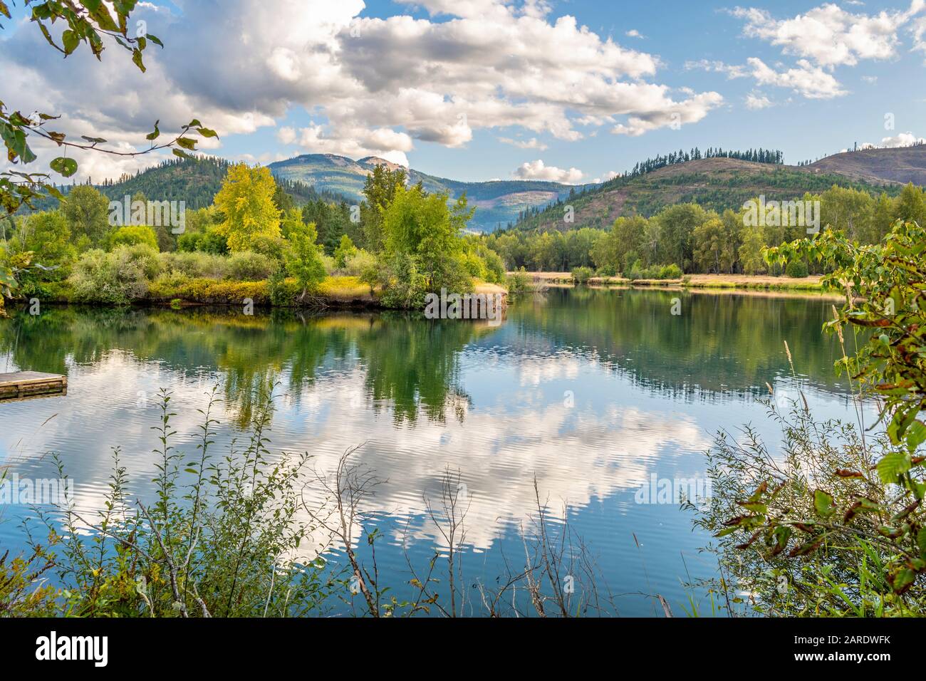 Una serena giornata estiva, parzialmente nuvoloso, sul fiume Coeur d'Alene nella zona della Silver Valley nel nord dell'Idaho, Stati Uniti Foto Stock