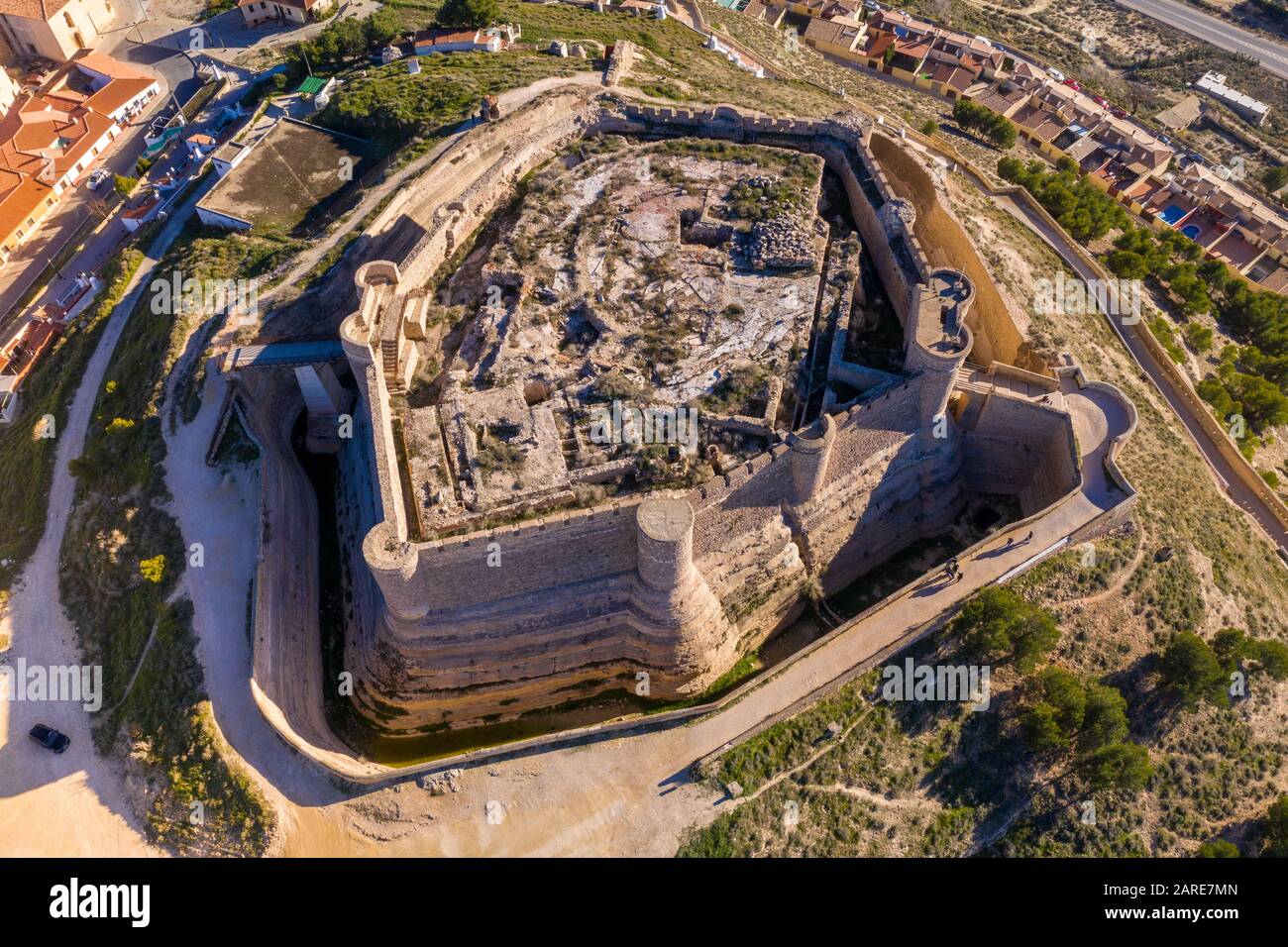Veduta aerea del castello di Chinchilla de Montearagon con rovine di edifici interni scavati resti circondato da una parete esterna con torri semi circolari Foto Stock