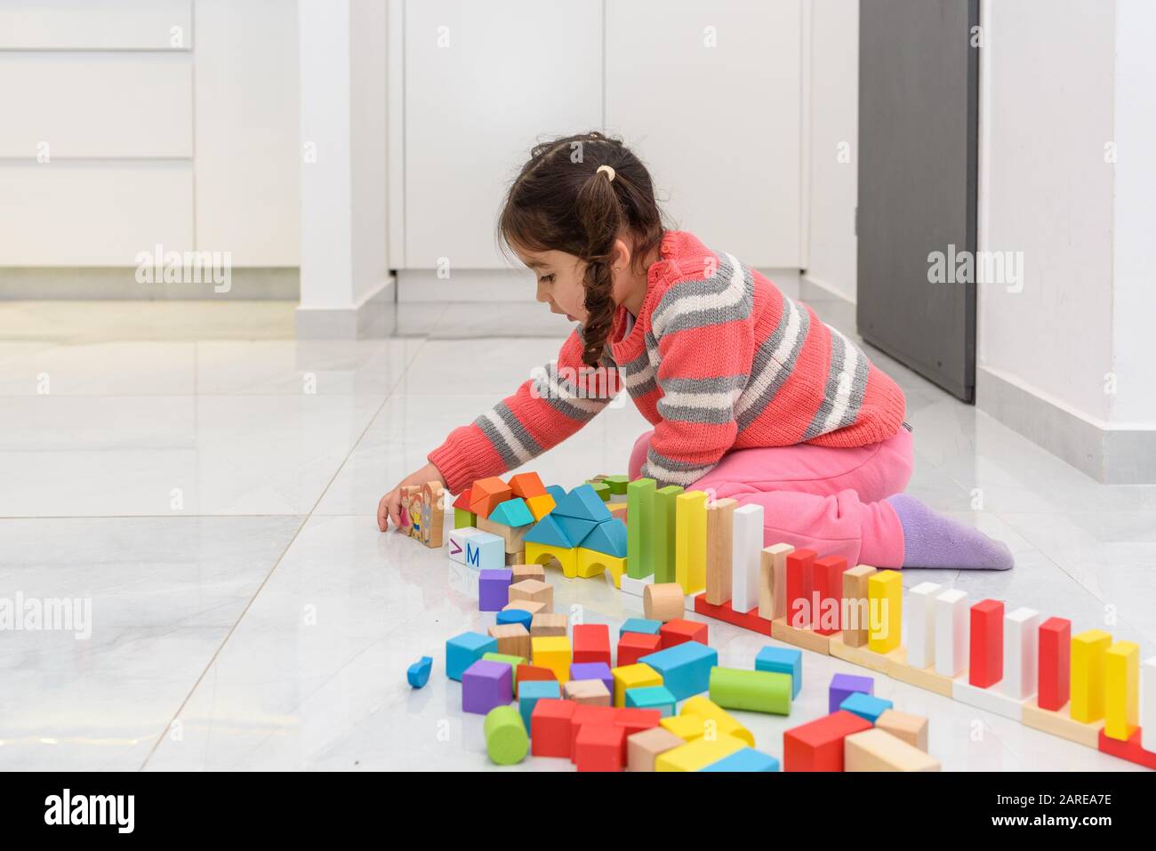 Cute toddler giocare con zero rifiuti giocattoli, colore diverso e forma blocchi giocattolo di legno. Foto Stock