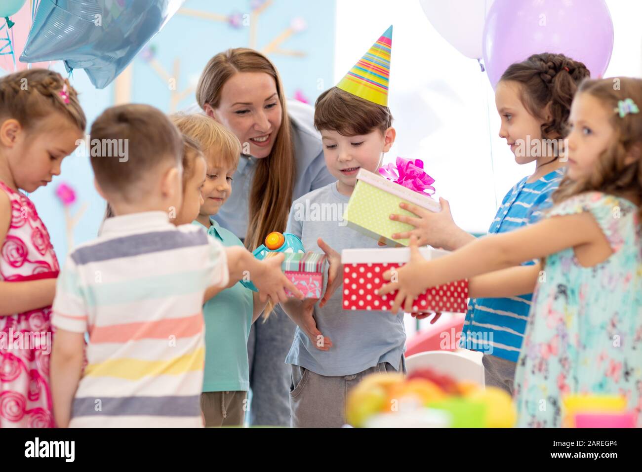 Infanzia, vacanze, celebrazione, amicizia e il concetto di popolo. Dei bambini felici in party cappelli regali di compleanno Foto Stock