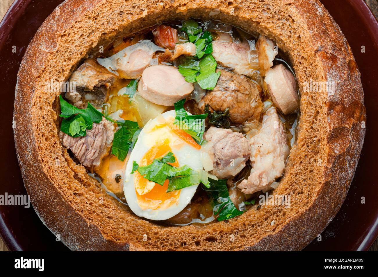 Zurek tradizionale zuppa polacca, in una pagnotta di pane. Piatto nazionale di cucina polacca. Foto Stock