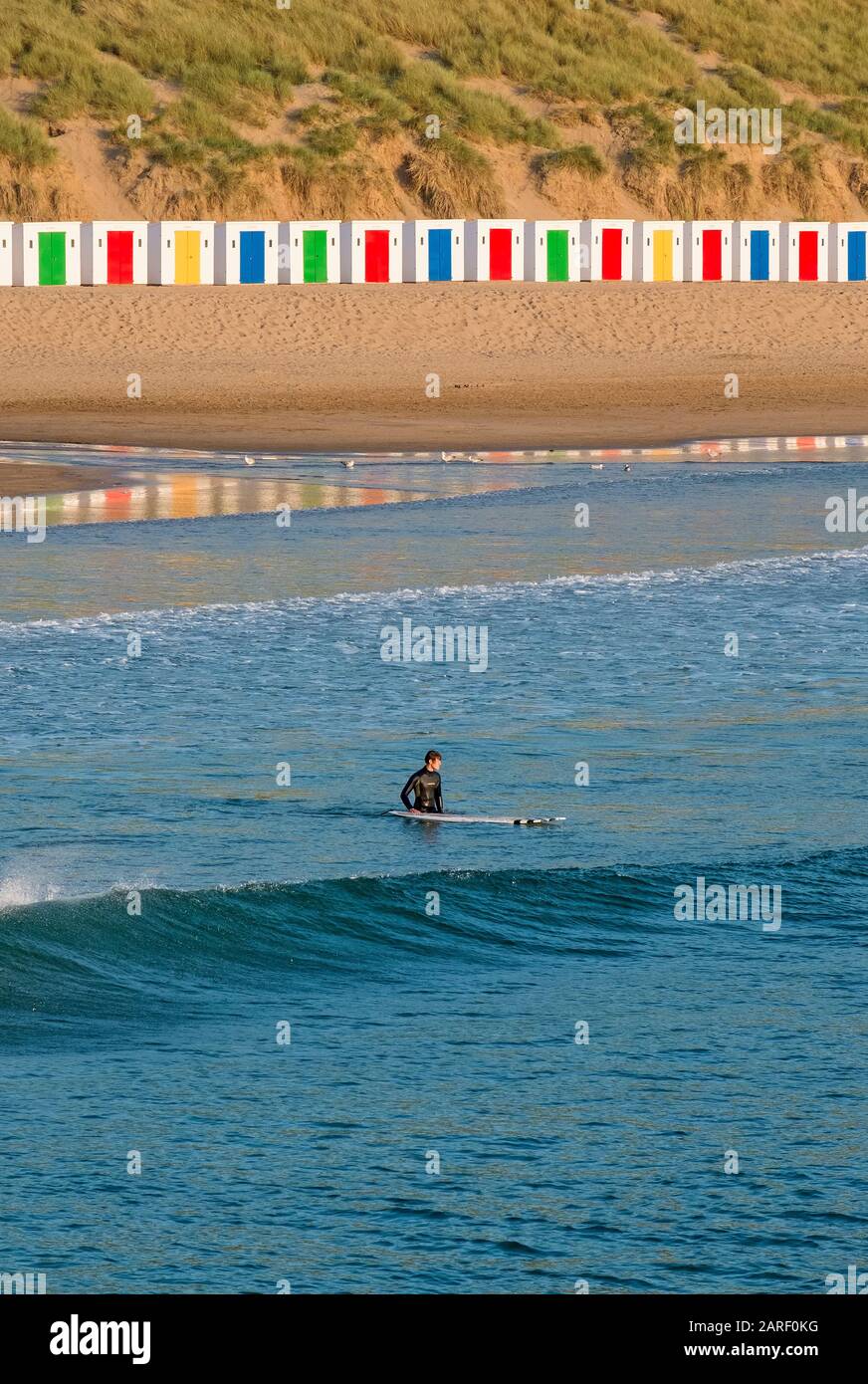 Spiaggia di Saunton Sands con dune di sabbia e una linea di capanne colorate e dipinte sulla spiaggia di Surf a North Devon, South West, UK Foto Stock