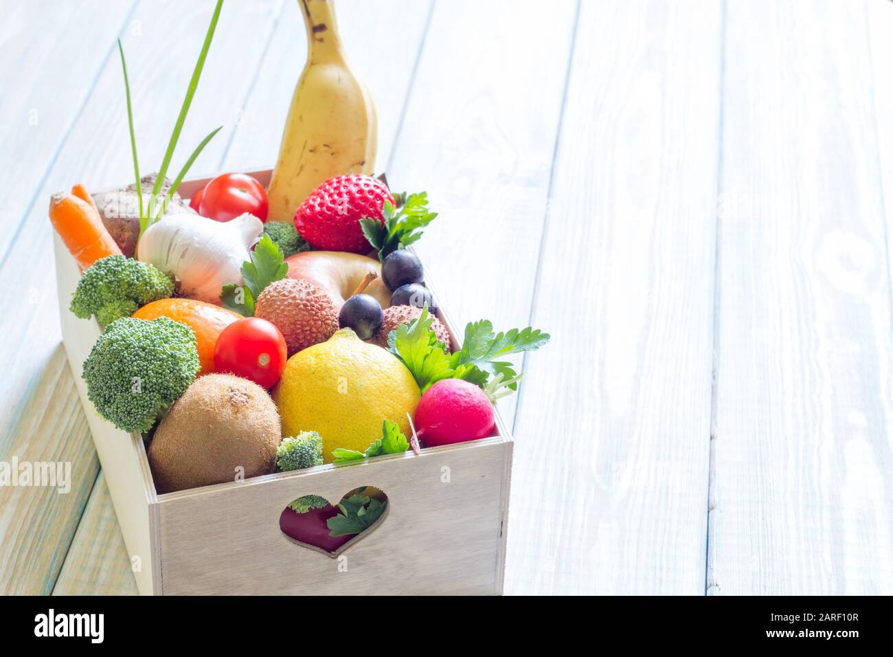 Dieta sana di concetto di lifestyle e nutrizione con gli alimenti della frutta e delle verdure nel cuore della scatola Foto Stock