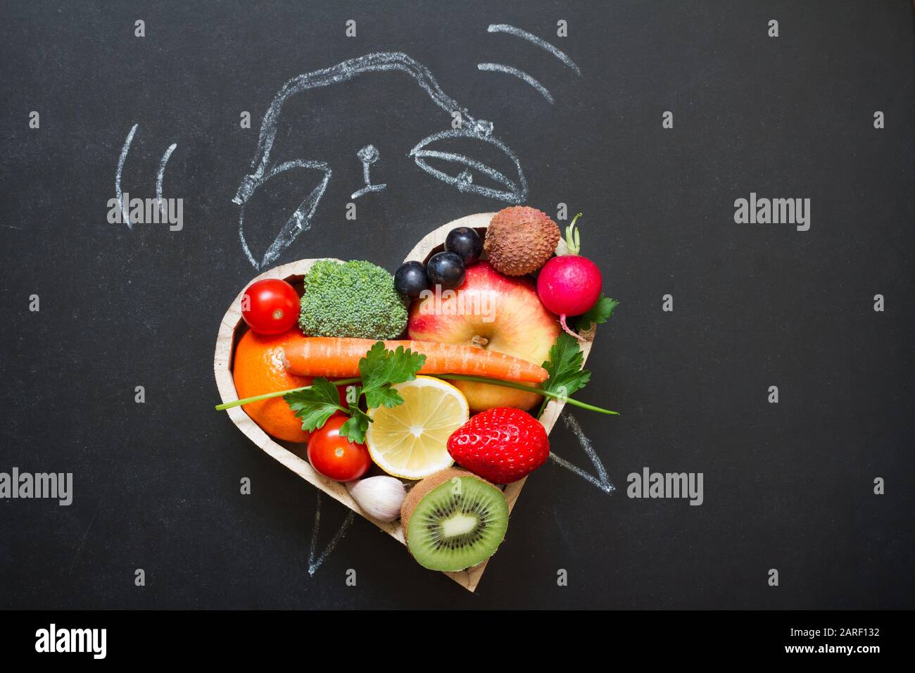 Allarme di tempo su dieta e concetto sano di lifestyle con frutta e verdure e orologio sulla lavagna Foto Stock