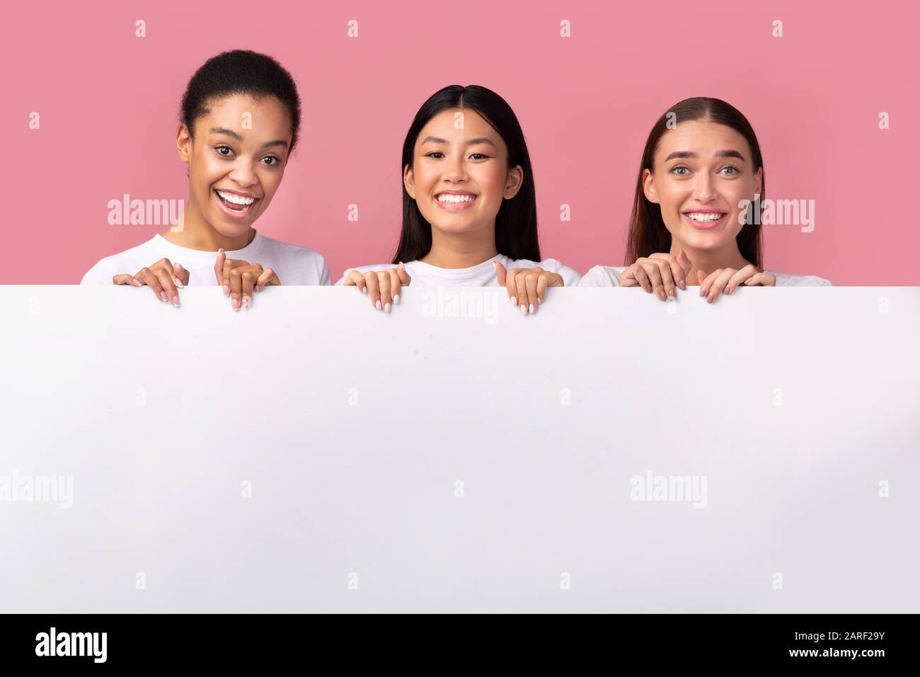 Tre Diverse Donne Che Tiene Blank White Board, Sfondo Rosa, Mockup Foto Stock