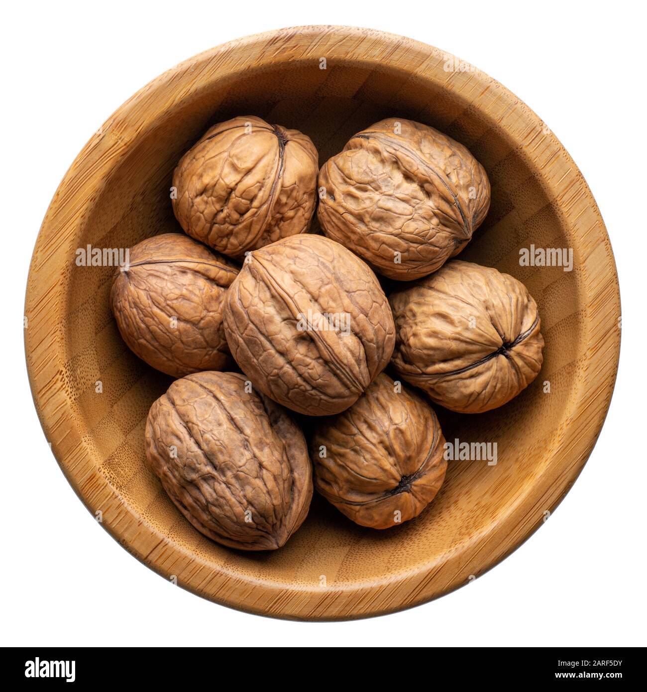Cibo e bevande: Gruppo di noci non sbucciate in una ciotola rotonda di legno, isolato su sfondo bianco Foto Stock