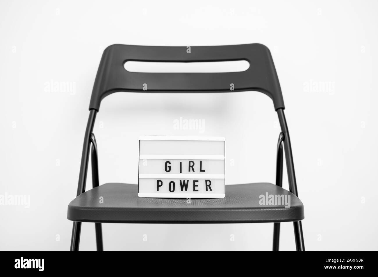 Testo alimentazione ragazza sulla scatola luminosa. Sfondo bianco. Parità dei diritti di genere. Democrazia Foto Stock