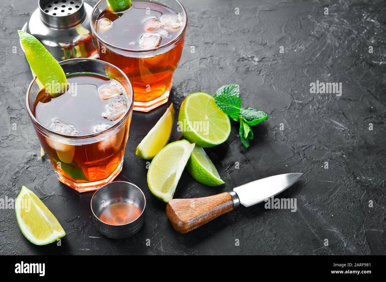 Bevande alcoliche Rum, lime e menta su sfondo di pietra nera. Vista dall'alto. Spazio libero per il testo. Foto Stock