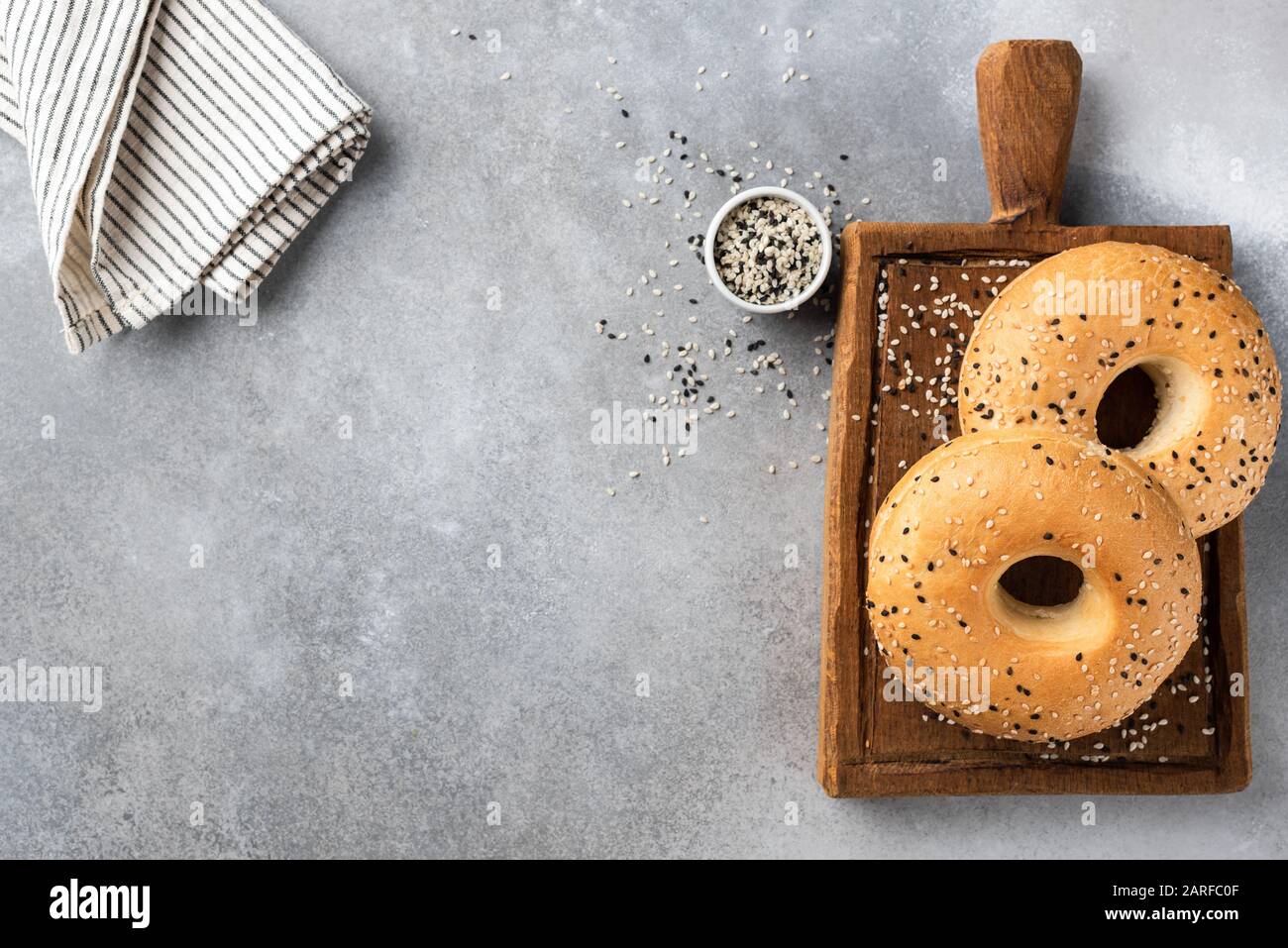 Due bagel di sesamo, sfondo grigio in cemento. Copiare lo spazio per il testo Foto Stock
