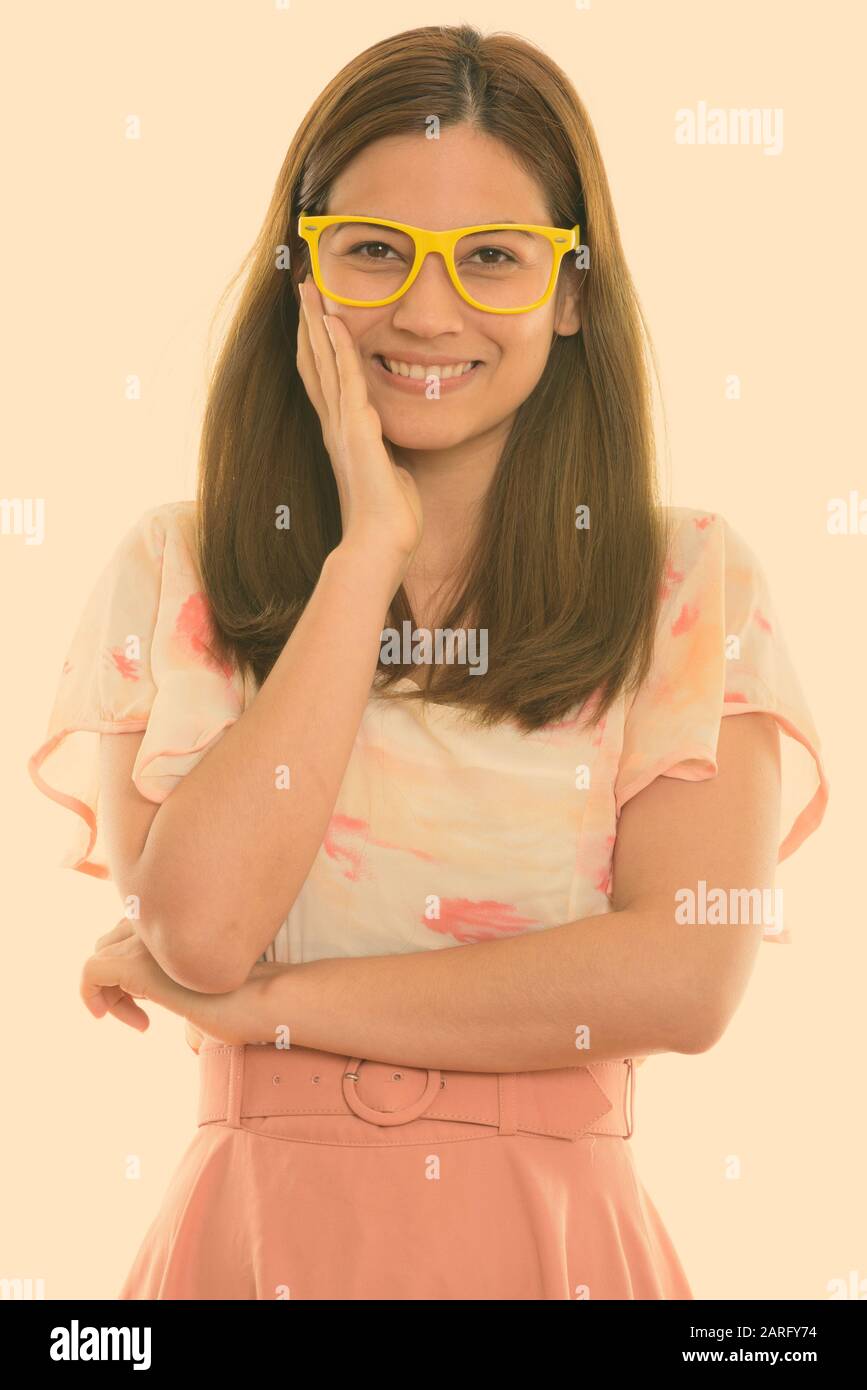 Studio shot di felice giovane bella donna sorridente e toccando la sua guancia indossando occhiali da vista Foto Stock