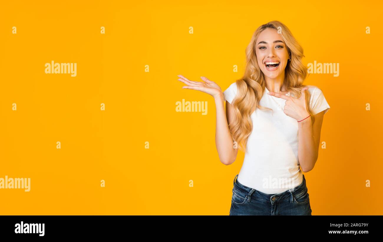 Ragazza overjoyed che punta il dito su palmo aperto, spazio libero Foto Stock