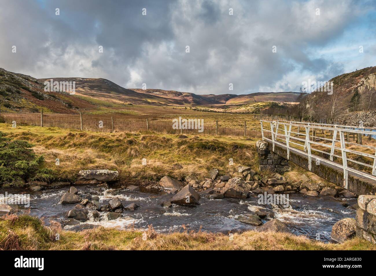 Il ponte pedonale Pennine Way sopra Beck Beck Beck guardando verso Cronkley Cadde in forte sole di gennaio Foto Stock