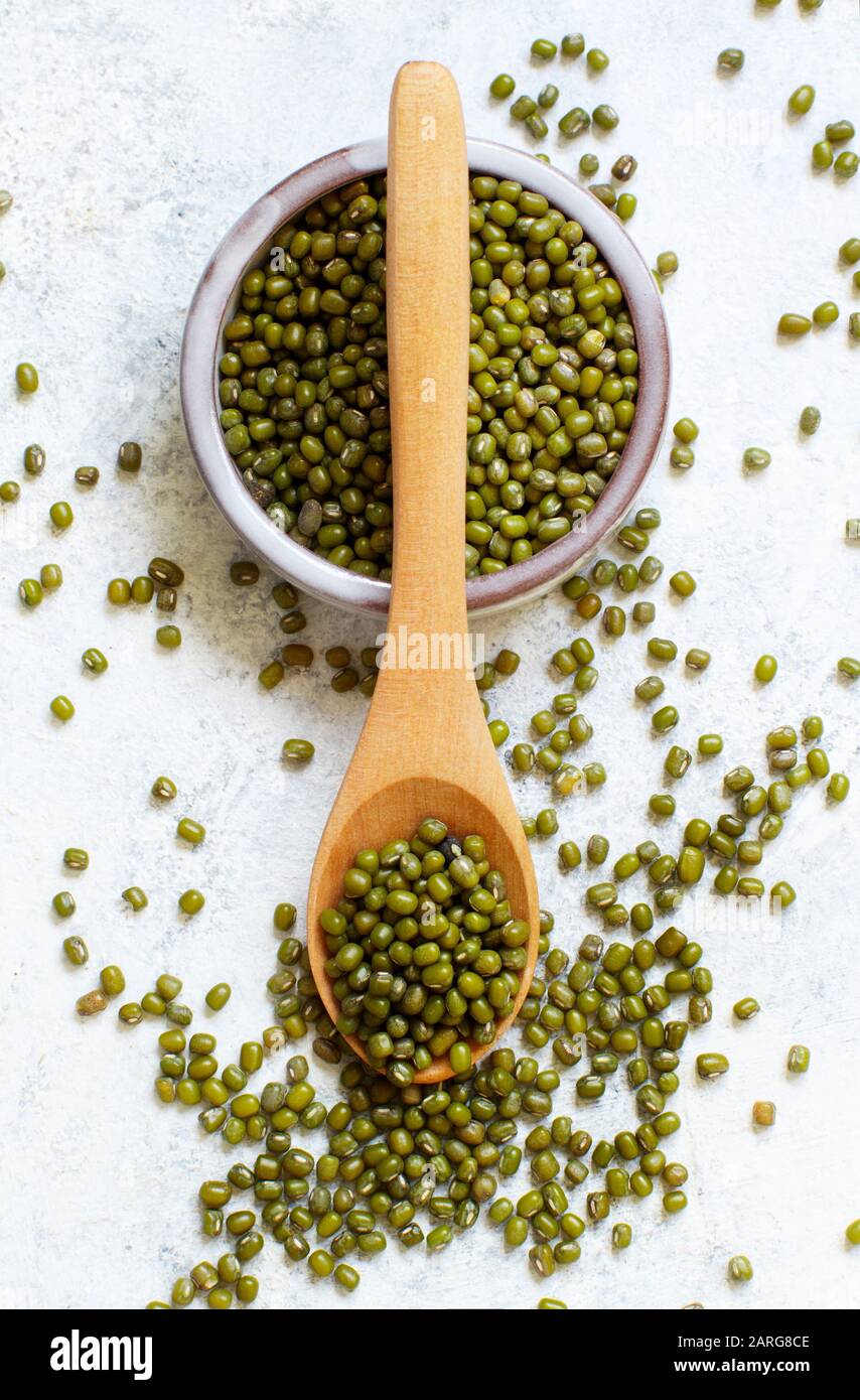 Fagioli bianchi secchi in una ciotola con una vista dall'alto del cucchiaio di legno Foto Stock