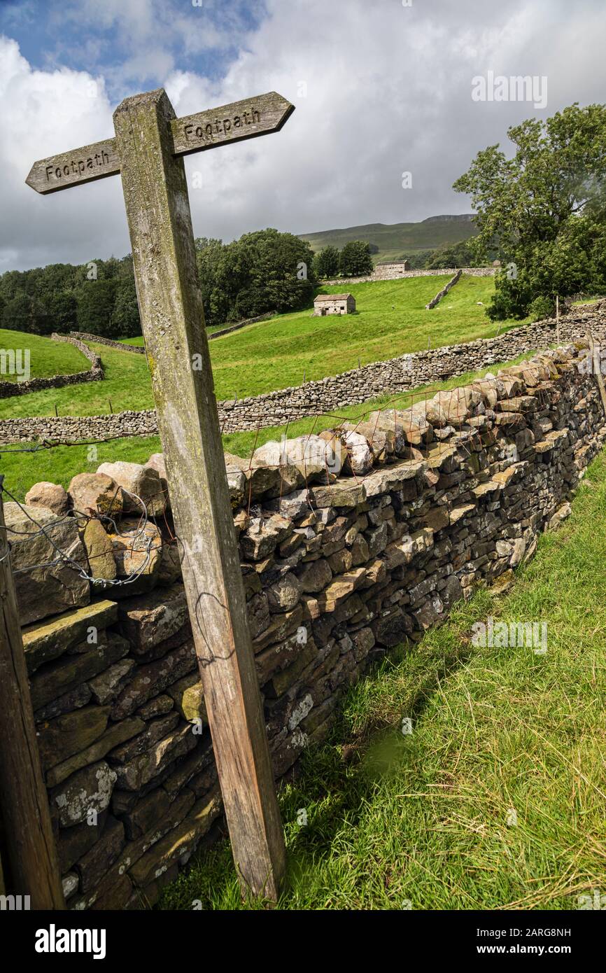 Segno del sentiero e muro di pietra a secco vicino a Sedbusk, Wensleydale, Yorkshire Dales Foto Stock