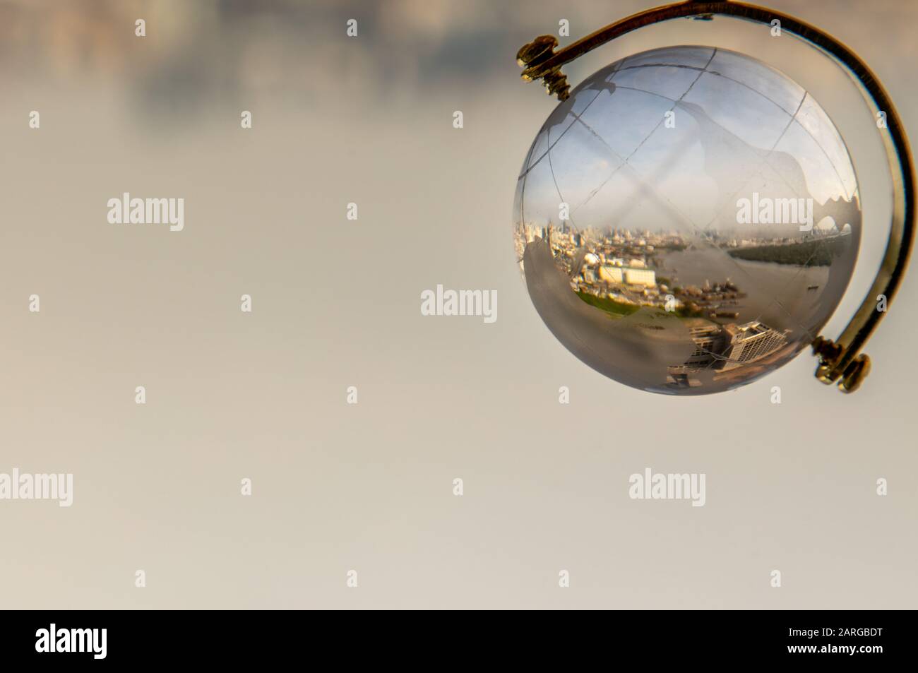 Guardando attraverso il globo di cristallo che mostra lo skyline della città. Fotographia di rifrazione. Messa a fuoco selettiva Foto Stock