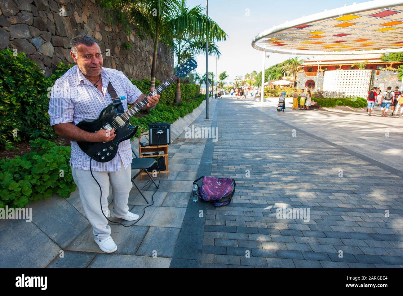 Canary ISLAND TENERIFE, SPAGNA - 27 dicembre 2019: Un artista di strada che suona la chitarra su plaza Duque. E' un viale con negozi vicino alla famosa spiaggia di P. Foto Stock