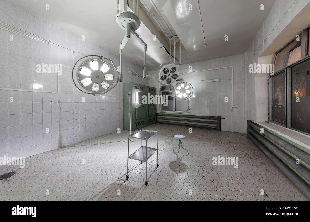 Sala operatoria con illuminazione senza ombre in un ospedale abbandonato. Foto Stock