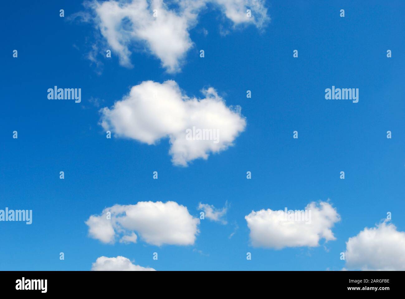 Poche divertenti nuvole a forma di pecora in cielo blu Foto Stock