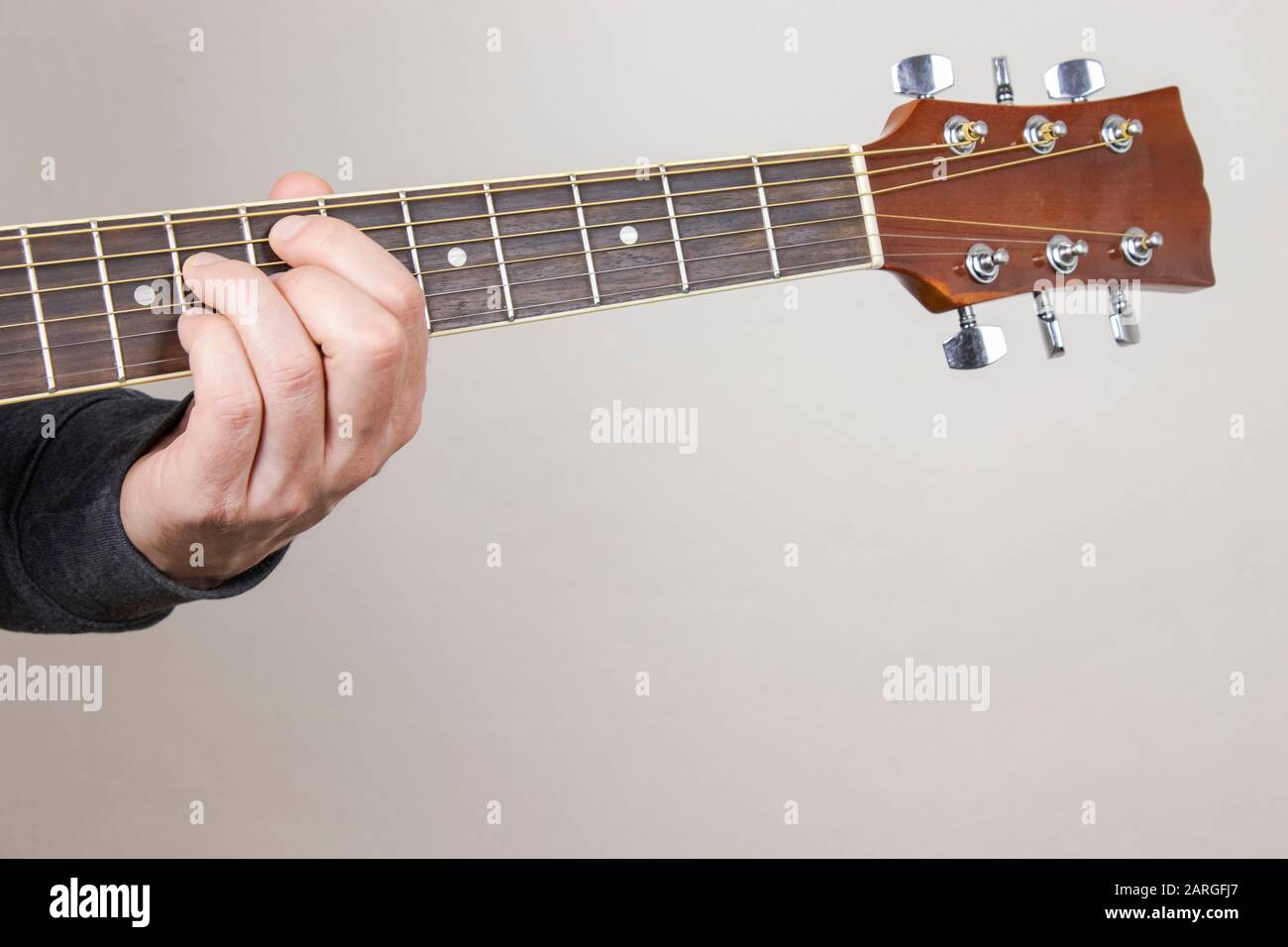 Chitarra giocatore Mano o musicista Mano in jazz Chord su chitarra acustica, sfondo Isolato Foto Stock
