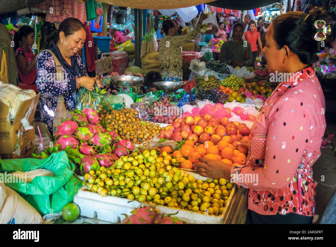 Donna che fa shopping in una stalla di frutta nel mercato centrale in questa vecchia città coloniale del fiume, Kambot, Cambogia, Indochina Foto Stock