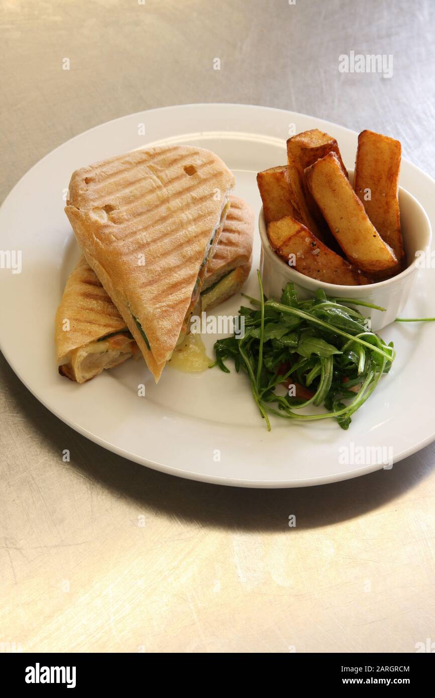 Un panino con formaggio fuso ed erbe aromatiche con patatine fritte Foto Stock