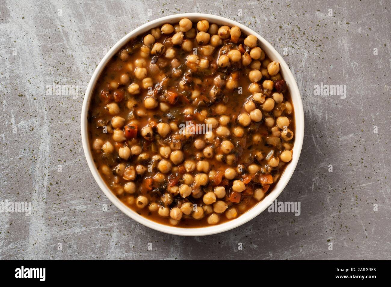 vista ad alto angolo di un piatto con uno stufato di ceci vegetariano con alghe kombu, su una superficie rustica grigia Foto Stock