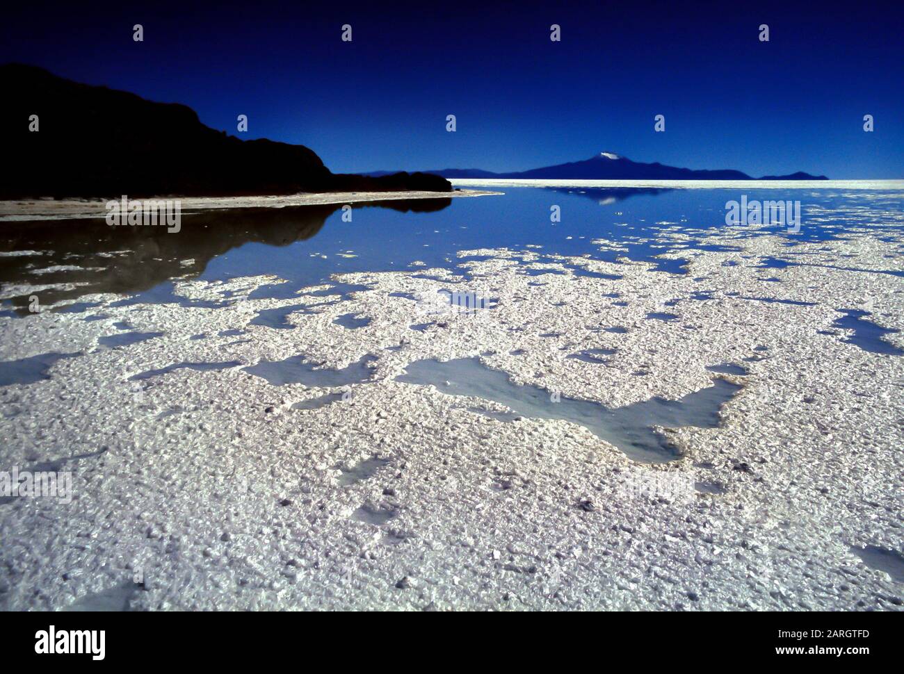Salar de Uyuni, Bolivia, America Latina: La distesa di sale in primo piano e le sagome dell'isola di Pescado sullo sfondo Foto Stock